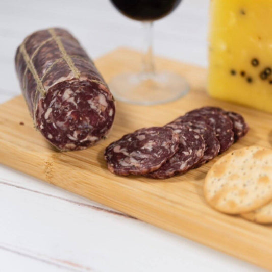 Beef and Horseradish Salami on a cheese platter served with red wine