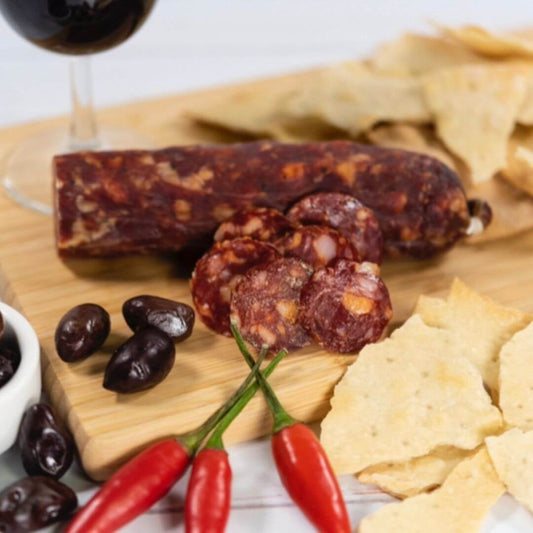 Cacciatore Chill Salami on a charcuterie board with olives, chilli, crackers and wine